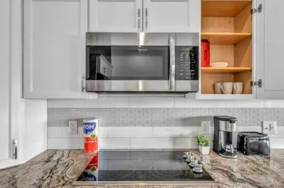 a kitchen with white cabinets and a microwave at Lux Flat Overlooking Guardians Field! Parking $ in Cleveland