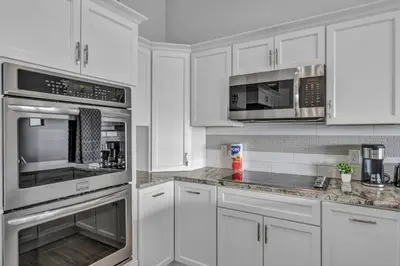 a kitchen with white cabinets and stainless steel appliances at Lux Flat Overlooking Guardians Field! Parking $ in Cleveland
