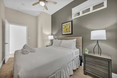 a bedroom with a large bed and a ceiling fan at Lux Flat Overlooking Guardians Field! Parking $ in Cleveland