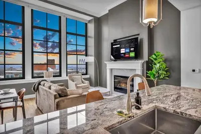 a kitchen with a living room with a fireplace at Lux Flat Overlooking Guardians Field! Parking $ in Cleveland