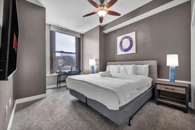 a bedroom with a large bed with a ceiling fan at Location! Playhouse Sq ~ Fast Wi-Fi ~ Walkscore 96 in Cleveland