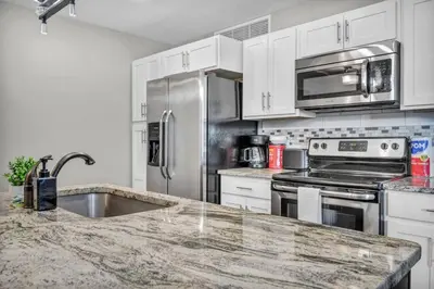 a kitchen with stainless steel appliances and a granite counter top at Gorgeous Downtown Flat| Parking•Gym•Security in Cleveland