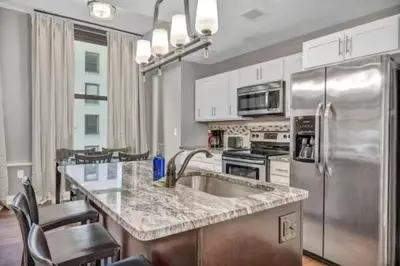 a kitchen with a stainless steel refrigerator and a sink at LUXE Condo Downtown | Security•Gym•Parking in Cleveland