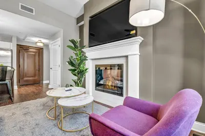 a living room with a purple couch and a fireplace at Luxury Loft • Heart of Downtown• Parking/Gym in Cleveland