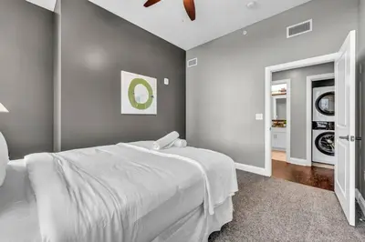 a bedroom with a white bed and a mirror at Luxury Loft • Heart of Downtown• Parking/Gym in Cleveland
