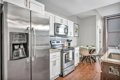 a kitchen with a stainless steel refrigerator and white cabinets at Perfect Luxury Flat • Heart of Downtown • Gym in Cleveland