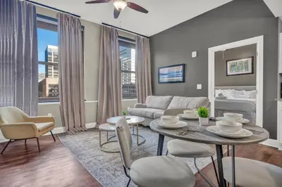 a living room with a table and chairs and a couch at Elegant Loft in the Heart of Downtown | Gym in Cleveland