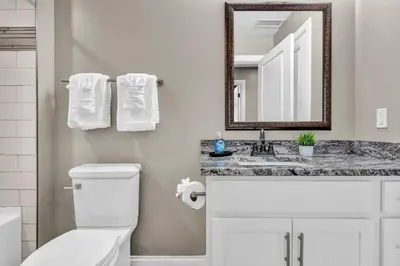 a bathroom with a toilet and a sink and a mirror at Central Downtown Loft | Parking•Gym•Security in Cleveland