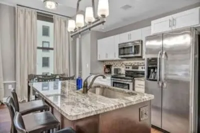 a kitchen with a stainless steel refrigerator and a sink at Central Downtown Loft | Parking•Gym•Security in Cleveland