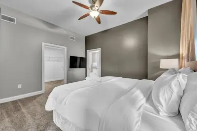 a bedroom with a white bed and a ceiling fan at Modern Loft in the Heart of Cleveland | Gym in Cleveland