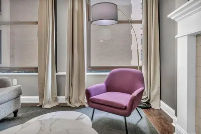 a purple chair sitting in a room with windows at Elegant 2BD Condo in the Heart of Downtown • Gym in Cleveland