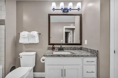 a bathroom with a toilet and a sink and a mirror at Elegant 2BD Condo in the Heart of Downtown • Gym in Cleveland