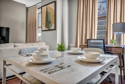 a living room with a table with dishes on it at Sophisticated Downtown Loft | Parking & Gym in Cleveland