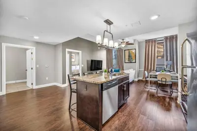 a kitchen and living room with a table and chairs at Sophisticated Downtown Loft | Parking & Gym in Cleveland