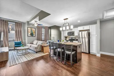 a kitchen and living room with a couch and a table at Sophisticated Downtown Loft | Parking & Gym in Cleveland