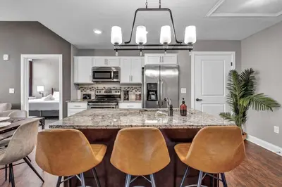 a kitchen with a large island with bar chairs at Luxury 2 BD Condo in the Heart of Downtown • Gym in Cleveland