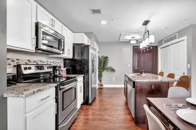 a kitchen with stainless steel appliances and wooden floors at Luxury 2 BD Condo in the Heart of Downtown • Gym in Cleveland