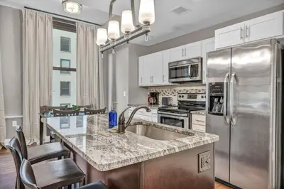 a kitchen with a sink and a refrigerator at Elegant Downtown Condo • Fitness Gym Included in Cleveland