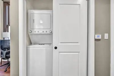 a kitchen with a washing machine and a white door at Elegant Downtown Condo • Fitness Gym Included in Cleveland