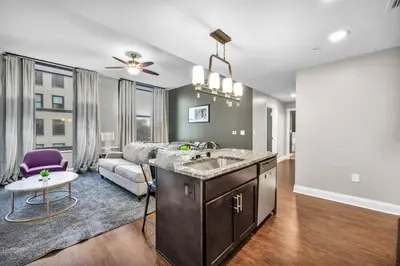a kitchen and living room with a sink and a couch at Luxury 2 Bedroom Loft in Heart of Downtown | Gym in Cleveland