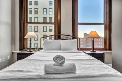 a bedroom with a bed with a large window at Luxury 2 Bedroom Loft in Heart of Downtown | Gym in Cleveland