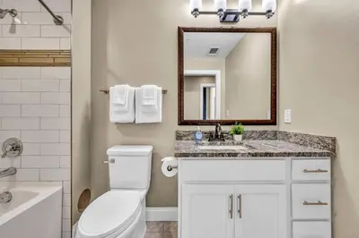 a bathroom with a toilet and a sink and a mirror at Luxury 2 Bedroom Loft in Heart of Downtown | Gym in Cleveland