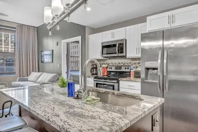 a kitchen with a sink and a refrigerator at Downtown Luxury Condo | Parking•Security•Gym in Cleveland