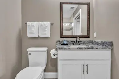 a bathroom with a toilet and a sink and a mirror at Downtown Luxury Condo | Parking•Security•Gym in Cleveland