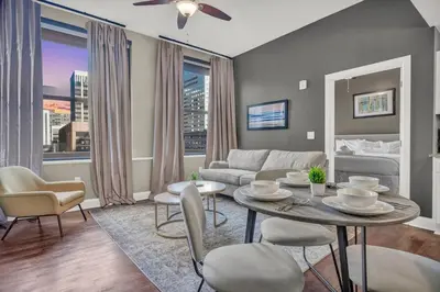 a living room with a table and chairs and a couch at Downtown Luxury Condo | Parking•Security•Gym in Cleveland