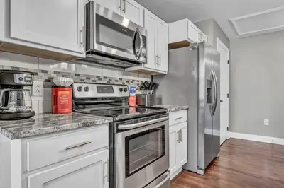 a kitchen with white cabinets and a stainless steel refrigerator at Downtown Luxury Condo | Parking•Security•Gym in Cleveland