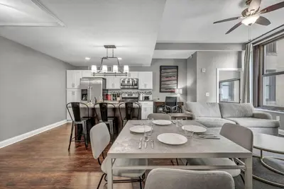 a kitchen and living room with a table and chairs at Upscale Downtown Loft | Parking • Gym in Cleveland