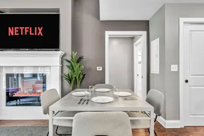 a dining room with a table with chairs and a tv at Upscale Downtown Loft | Parking • Gym in Cleveland