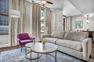 a living room with a couch and a purple chair at Stunning Downtown Condo with Parking & Gym in Cleveland
