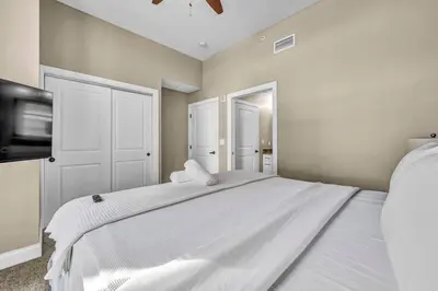 a bedroom with a large white bed and a tv at Stunning Downtown Condo with Parking & Gym in Cleveland