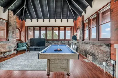 a pool table in a room with a brick wall at Urban Industrial Penthouse | Game Room Pool Table in Cleveland