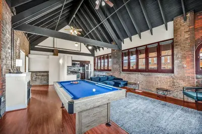 a pool table in a room with a brick wall at Urban Industrial Penthouse | Game Room Pool Table in Cleveland