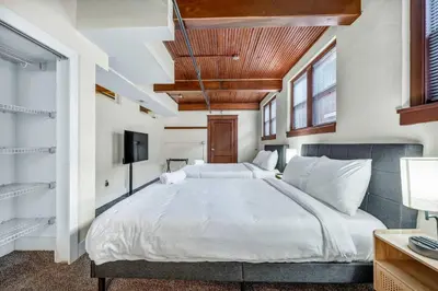 a bedroom with a large bed and a tv at Urban Industrial Penthouse | Game Room Pool Table in Cleveland