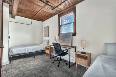a bedroom with two beds and a desk and a chair at Urban Industrial Penthouse | Game Room Pool Table in Cleveland
