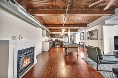 a living room with a fireplace and a table at Penthouse Vibes • Fun, Space & City Views in Cleveland