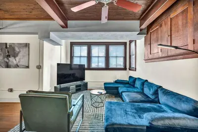a living room with a blue couch and a tv at Penthouse Vibes • Fun, Space & City Views in Cleveland