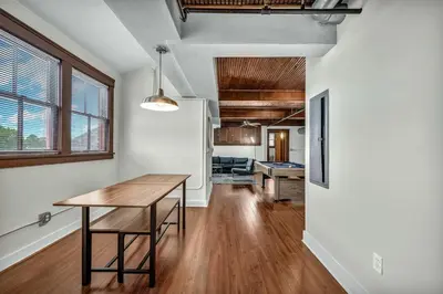 a kitchen and dining room with a wooden table in a room at Penthouse Vibes • Fun, Space & City Views in Cleveland
