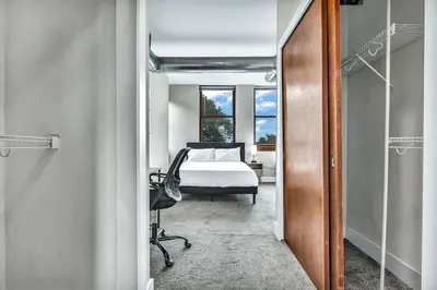 a bedroom with a bed and a desk and a chair at Penthouse Vibes • Fun, Space & City Views in Cleveland