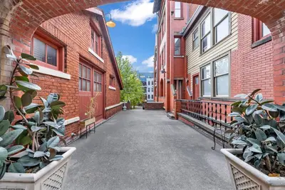 an alley between two brick buildings with potted plants at Penthouse Vibes • Fun, Space & City Views in Cleveland