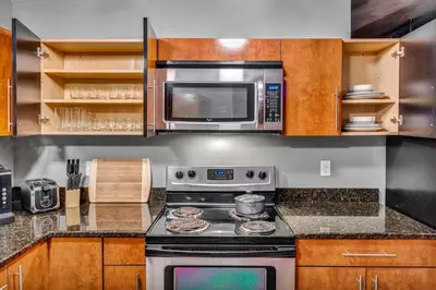 a kitchen with a stove and a microwave at Unique 3BD Tremont Apartment in Cleveland
