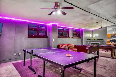 a ping pong table in a room with purple lights at Unique 3BD Tremont Apartment in Cleveland