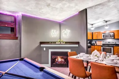 a dining room with a pool table and a fireplace at Unique 3BD Tremont Apartment in Cleveland