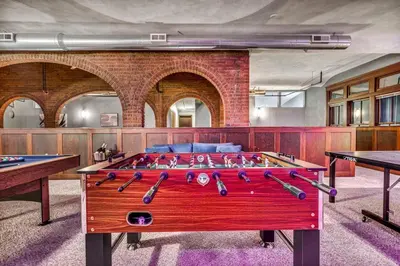 a ping pong table in a room with two tables at Unique 3BD Tremont Apartment in Cleveland