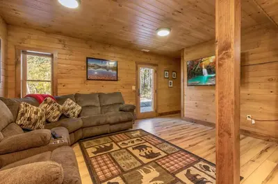 a living room with a couch in a log cabin at Whiskey Ridge in Logan