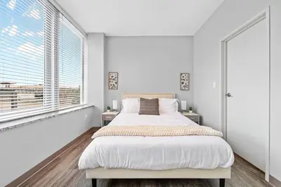 a white bedroom with a large bed and a window at Bright Downtown 1BR l Free Parking l Fast Wi-Fi in Cleveland