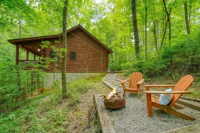 a backyard with two chairs and a fire pit and a cabin at Havenridge in Logan